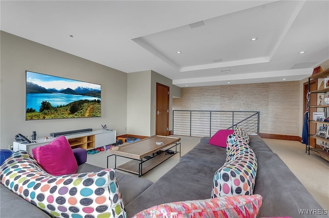 living room with carpet flooring and a tray ceiling