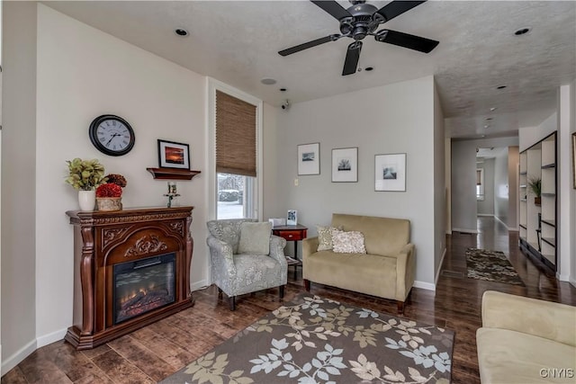 sitting room featuring dark wood-type flooring and ceiling fan