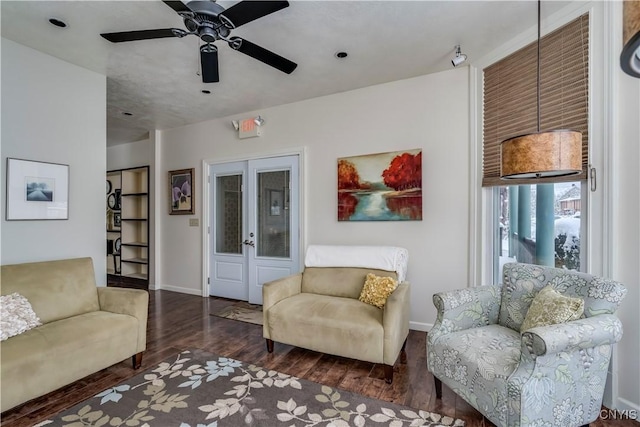 living room with dark wood-type flooring and ceiling fan