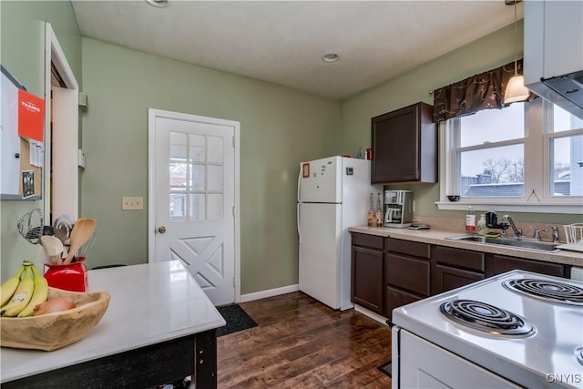 kitchen with dark brown cabinetry, sink, white appliances, and dark hardwood / wood-style flooring