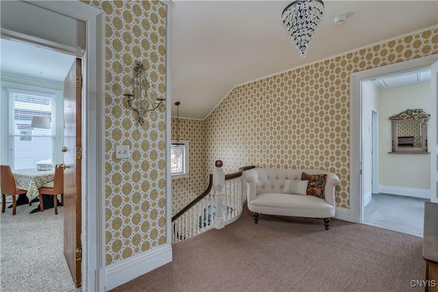 sitting room featuring vaulted ceiling, crown molding, and carpet floors