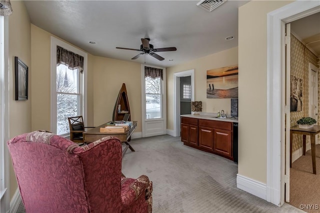 carpeted living room with sink and ceiling fan