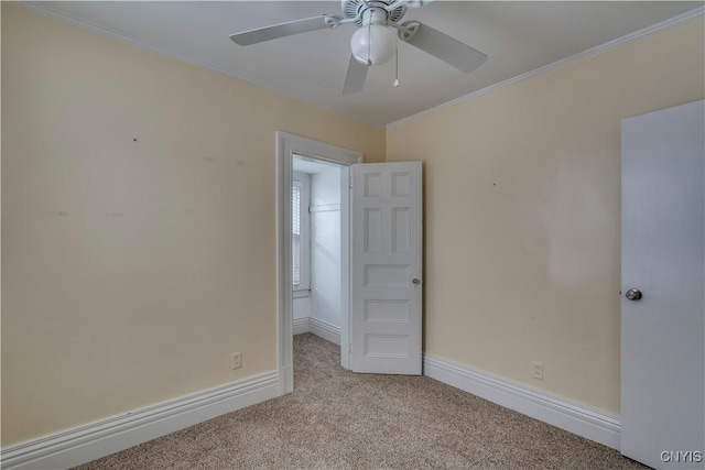 spare room featuring ornamental molding, light colored carpet, and ceiling fan