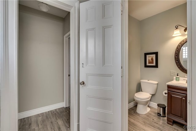 bathroom with hardwood / wood-style flooring, vanity, and toilet