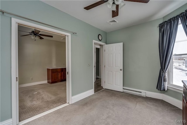 unfurnished bedroom with light carpet, a baseboard heating unit, and ceiling fan