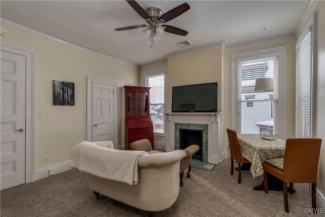 carpeted living room featuring crown molding, a fireplace, and ceiling fan