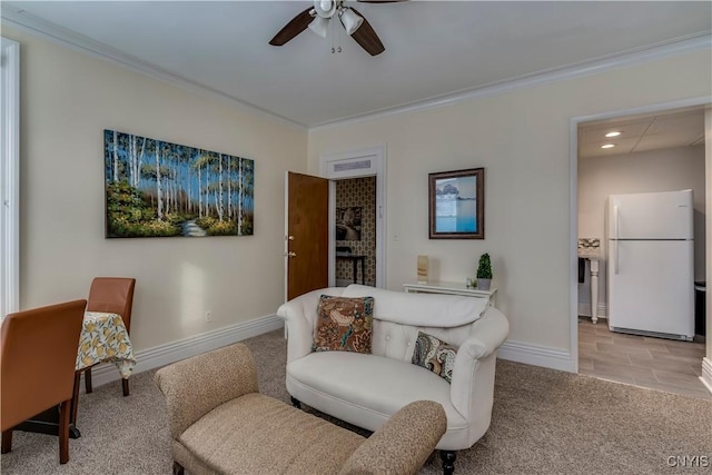 living area with ceiling fan, light colored carpet, and ornamental molding