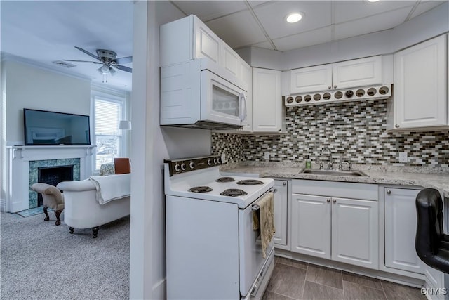 kitchen featuring sink, white appliances, a premium fireplace, backsplash, and white cabinets