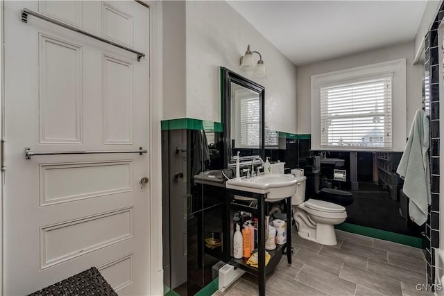 bathroom featuring vanity, tile walls, and toilet