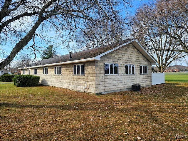 view of side of property with cooling unit and a lawn