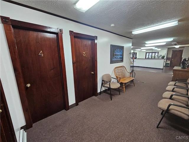 living area with a textured ceiling and dark colored carpet