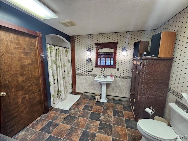 bathroom with a baseboard radiator and toilet