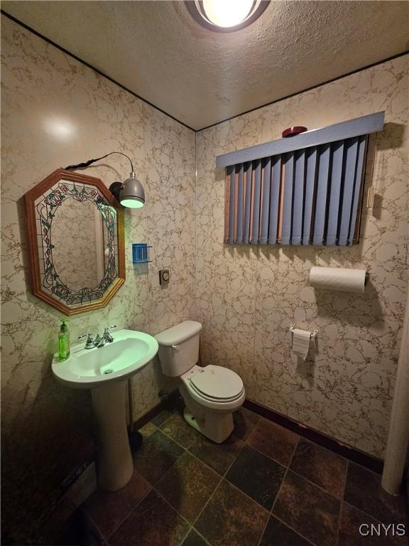 bathroom with a textured ceiling and toilet