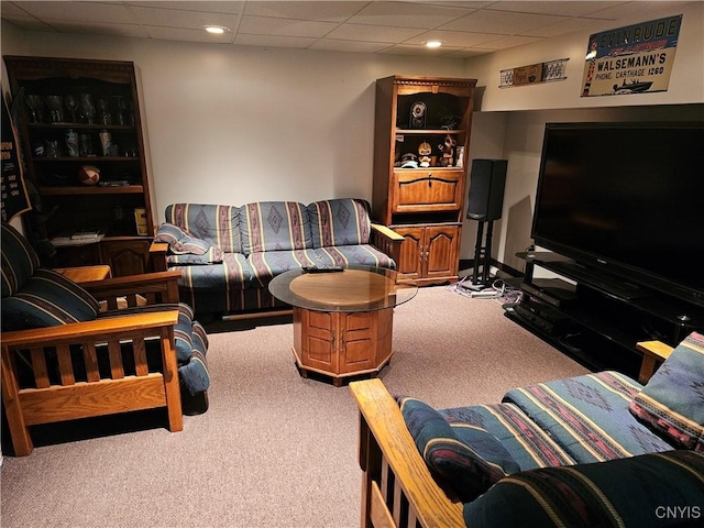 carpeted living room featuring a drop ceiling