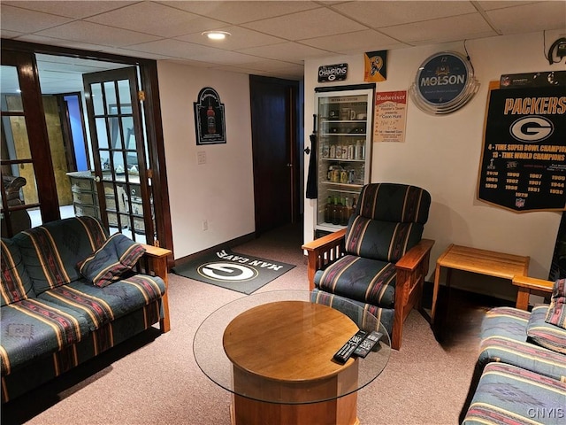 carpeted living room with a paneled ceiling