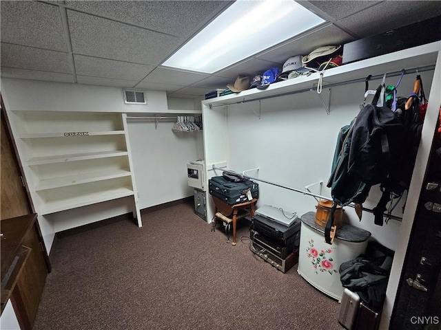 walk in closet with dark carpet and a paneled ceiling