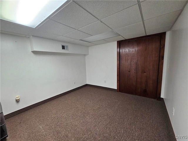 basement with carpet floors and a drop ceiling