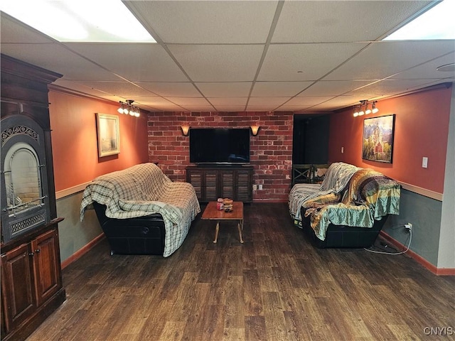 living room featuring dark wood-type flooring and a drop ceiling