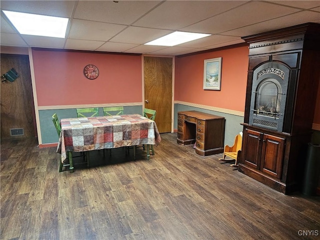 dining room featuring dark wood-type flooring and a paneled ceiling