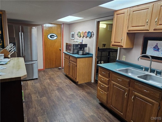 kitchen featuring appliances with stainless steel finishes, sink, and dark hardwood / wood-style floors