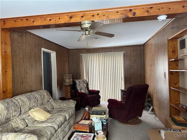 carpeted living room with ornamental molding, ceiling fan, and wood walls