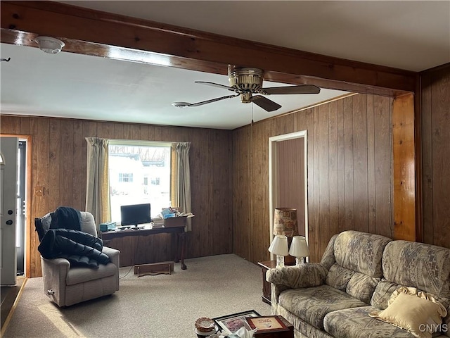 carpeted office with ceiling fan and wood walls