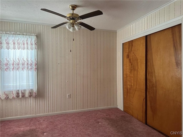 unfurnished bedroom with a textured ceiling, a closet, ceiling fan, and carpet