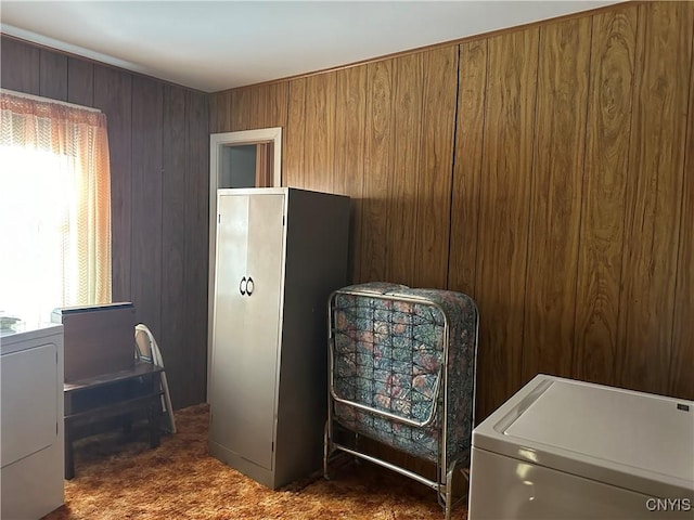 carpeted bedroom featuring washer / clothes dryer and wooden walls