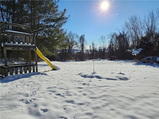 yard layered in snow featuring a playground