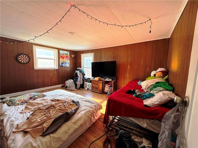 bedroom featuring hardwood / wood-style flooring and wooden walls