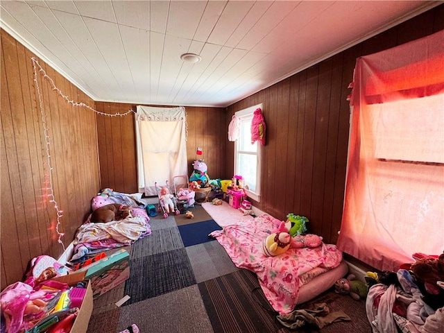 carpeted bedroom featuring wooden walls