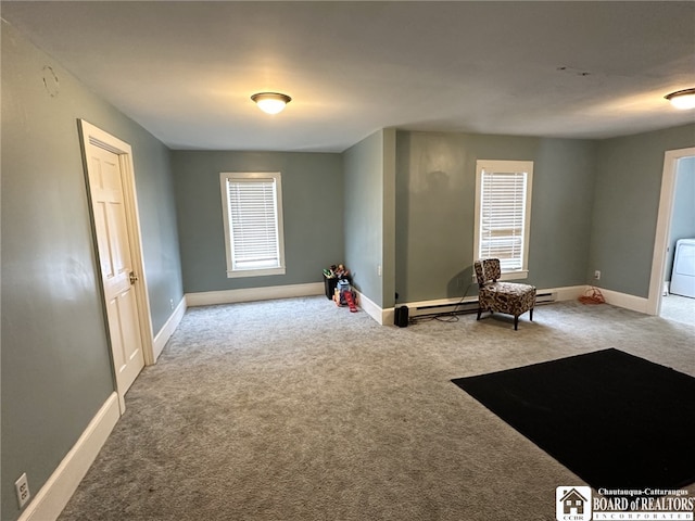 unfurnished room with washer / dryer, carpet floors, and a baseboard radiator