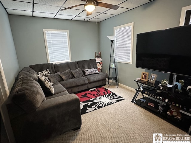 carpeted living room featuring ceiling fan and a paneled ceiling