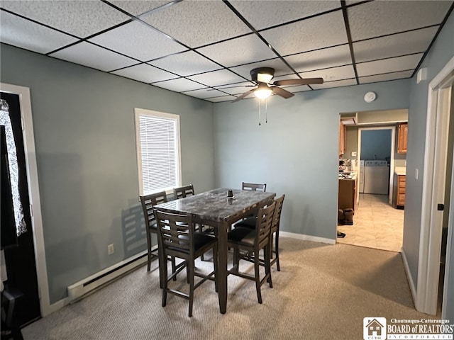 carpeted dining area featuring washer / clothes dryer, a baseboard radiator, a paneled ceiling, and ceiling fan