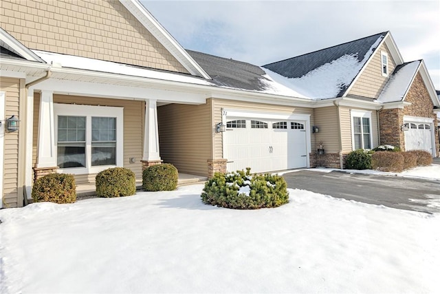 view of snowy exterior featuring a garage