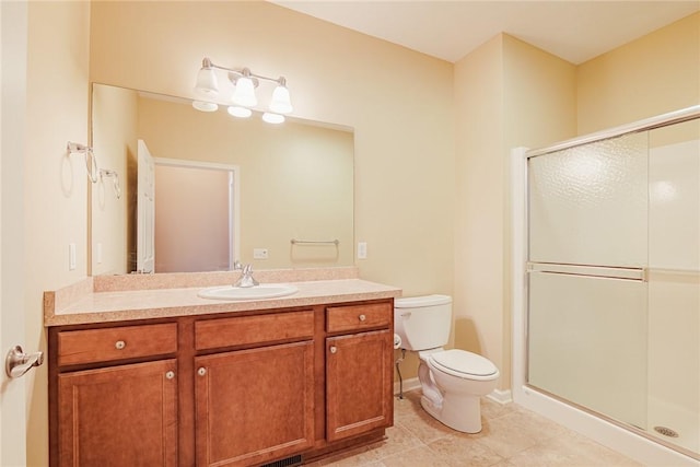 bathroom featuring vanity, tile patterned flooring, toilet, and walk in shower