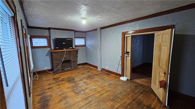 interior space with a fireplace, ornamental molding, dark hardwood / wood-style floors, and a textured ceiling