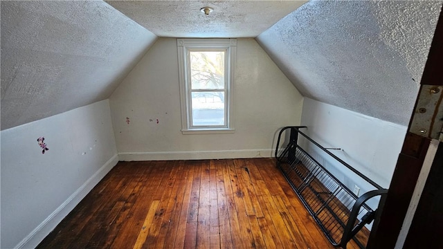 additional living space with lofted ceiling, hardwood / wood-style floors, and a textured ceiling