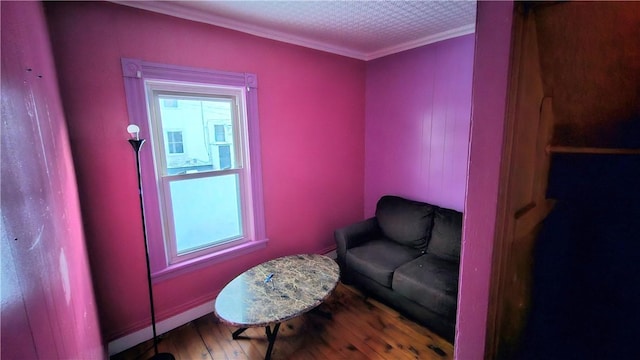 sitting room featuring crown molding, a wealth of natural light, and wood-type flooring