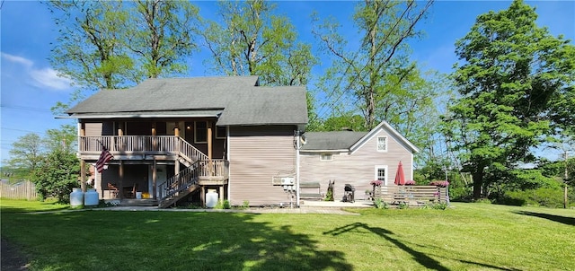 back of house featuring a wooden deck, a patio, and a lawn