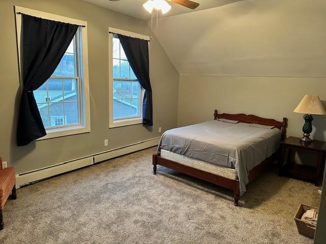 carpeted bedroom featuring a baseboard radiator, vaulted ceiling, and ceiling fan