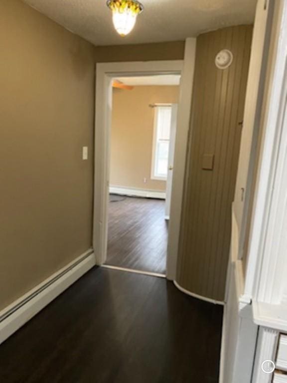 interior space with dark hardwood / wood-style floors and baseboard heating