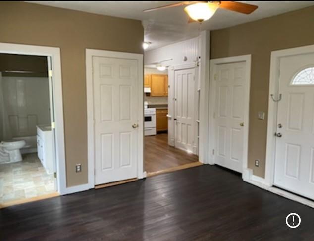 foyer entrance with dark hardwood / wood-style flooring and ceiling fan