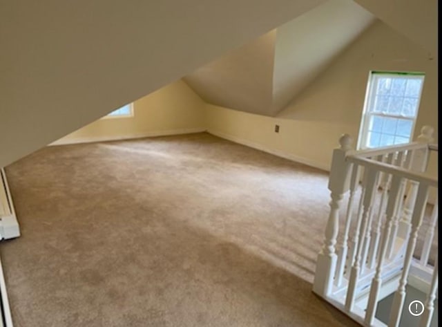 additional living space with a healthy amount of sunlight, lofted ceiling, and carpet floors