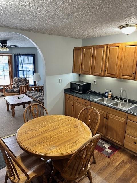 kitchen with ceiling fan, dark hardwood / wood-style flooring, sink, and a textured ceiling