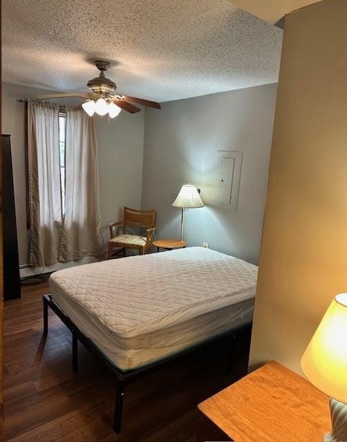 bedroom featuring dark wood-type flooring, a textured ceiling, and ceiling fan