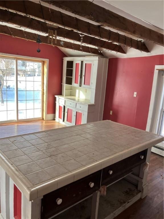 kitchen featuring vaulted ceiling with beams, tile countertops, and dark hardwood / wood-style floors