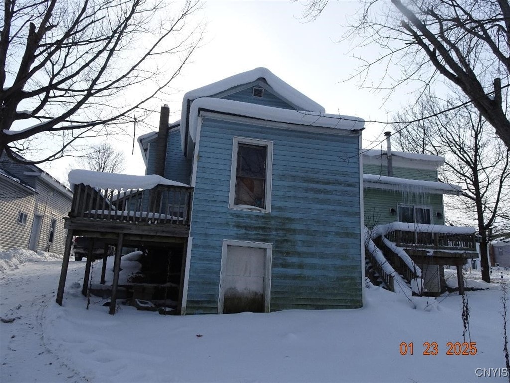 view of snow covered exterior with a wooden deck