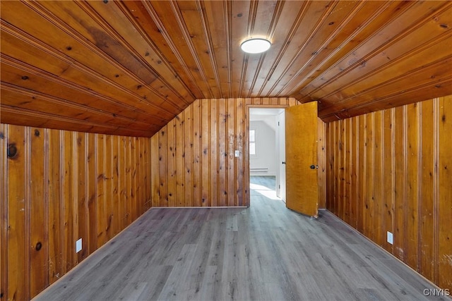 bonus room featuring light hardwood / wood-style flooring, wood ceiling, vaulted ceiling, and wood walls