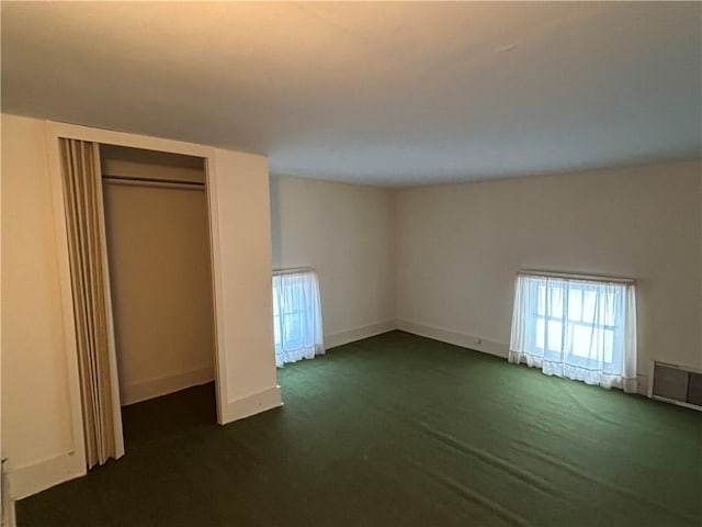 unfurnished bedroom featuring a closet and dark colored carpet